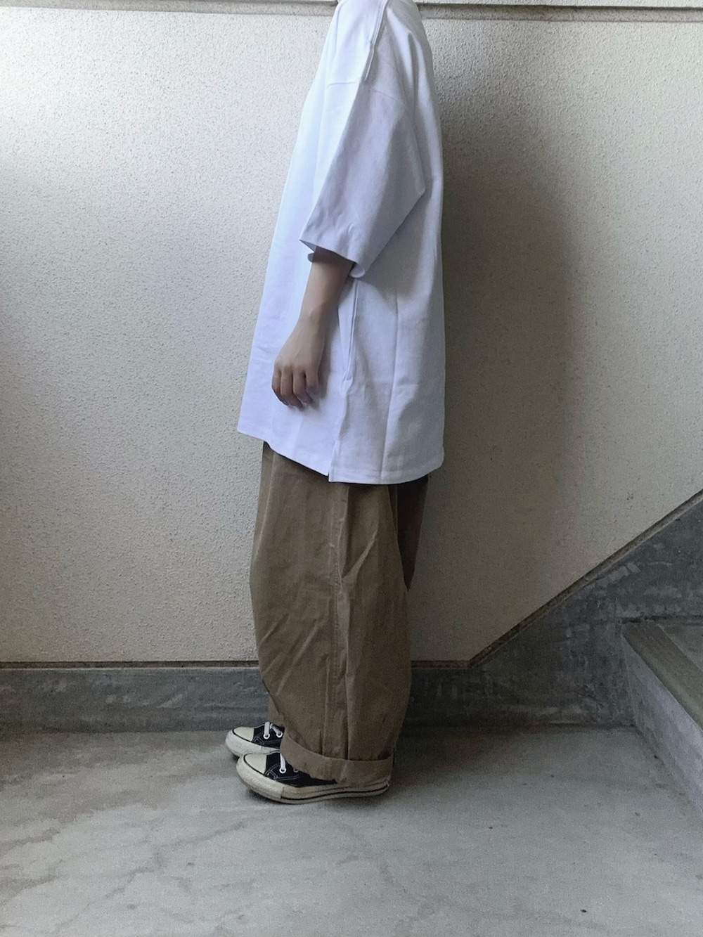 ホワイト系のTシャツ/カットソー、ベージュ系のチノパンツ、ブラック系のショルダーバッグを着用したレディースの夏コーディネートの5枚目の写真