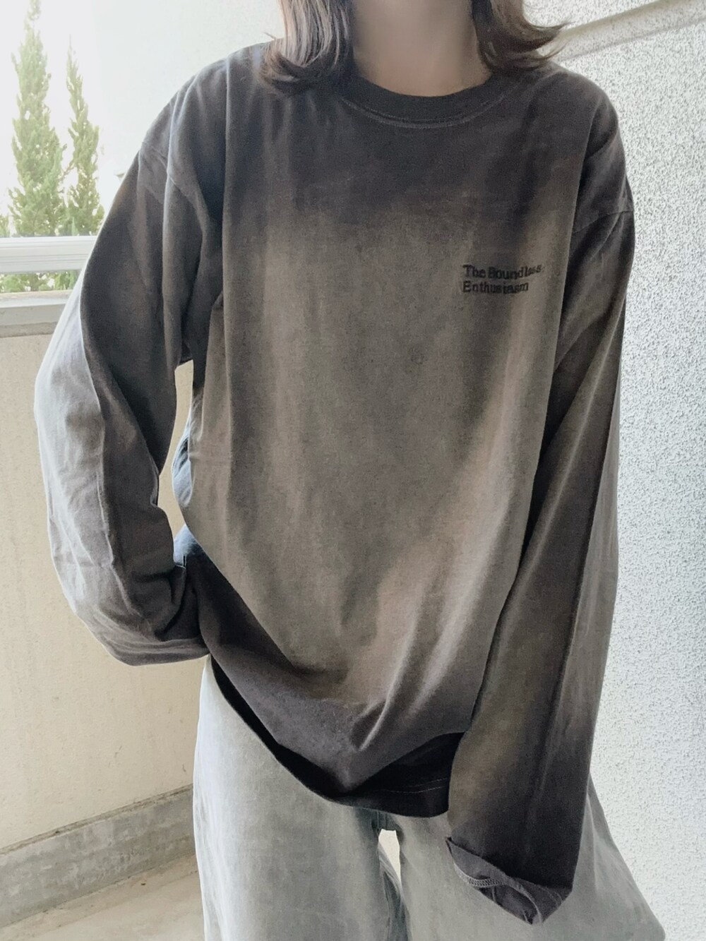 グレー系のTシャツ/カットソー、ブラック系のバックパック/リュック、グレー系のデニムパンツを着用したレディースの冬コーディネートの2枚目の写真