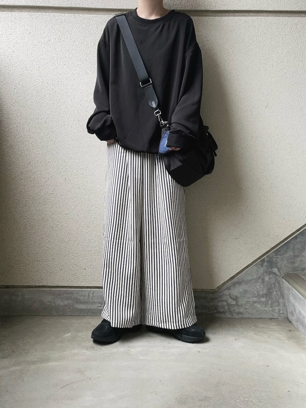 ブラック系のその他パンツ、ブラック系のTシャツ/カットソー、ブラック系のショルダーバッグを着用したレディースの春コーディネートの2枚目の写真