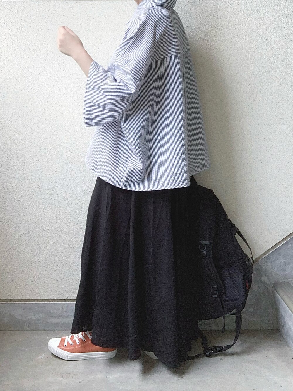 ブラック系のスカート、ブラック系のシャツ/ブラウス、オレンジ系のスニーカーを着用したレディースの夏コーディネートの4枚目の写真