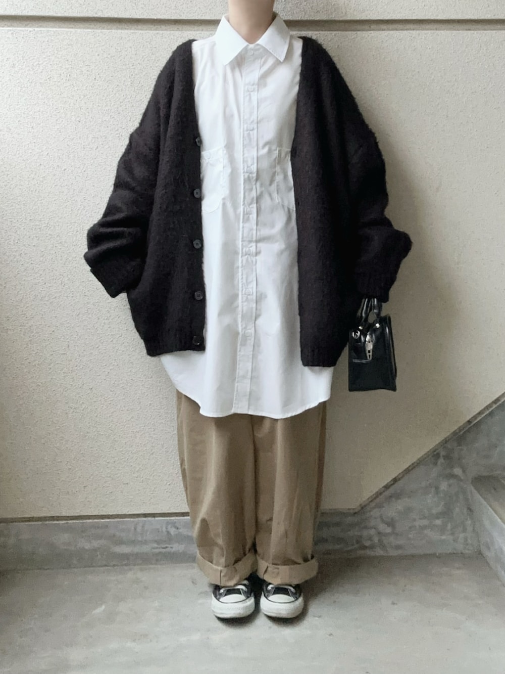 ホワイト系のシャツ/ブラウス、ベージュ系のチノパンツ、ブラック系のショルダーバッグを着用したレディースの冬コーディネートの2枚目の写真