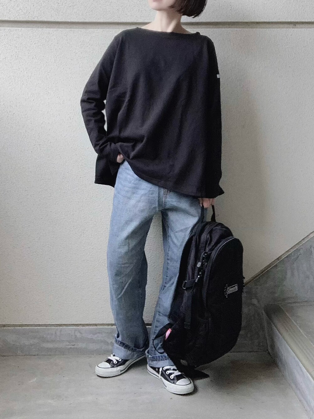 ブラック系のTシャツ/カットソー、ブルー系のデニムパンツ、ブラック系のバックパック/リュックを着用したレディースの冬コーディネートの2枚目の写真
