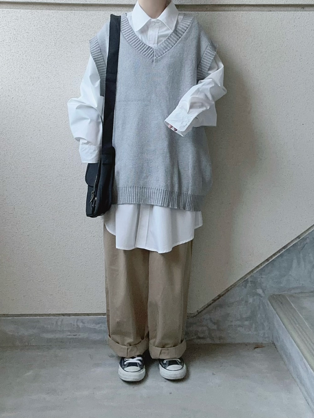 ホワイト系のシャツ/ブラウス、ブラック系のショルダーバッグ、ベージュ系のチノパンツを着用したレディースの冬コーディネートの2枚目の写真