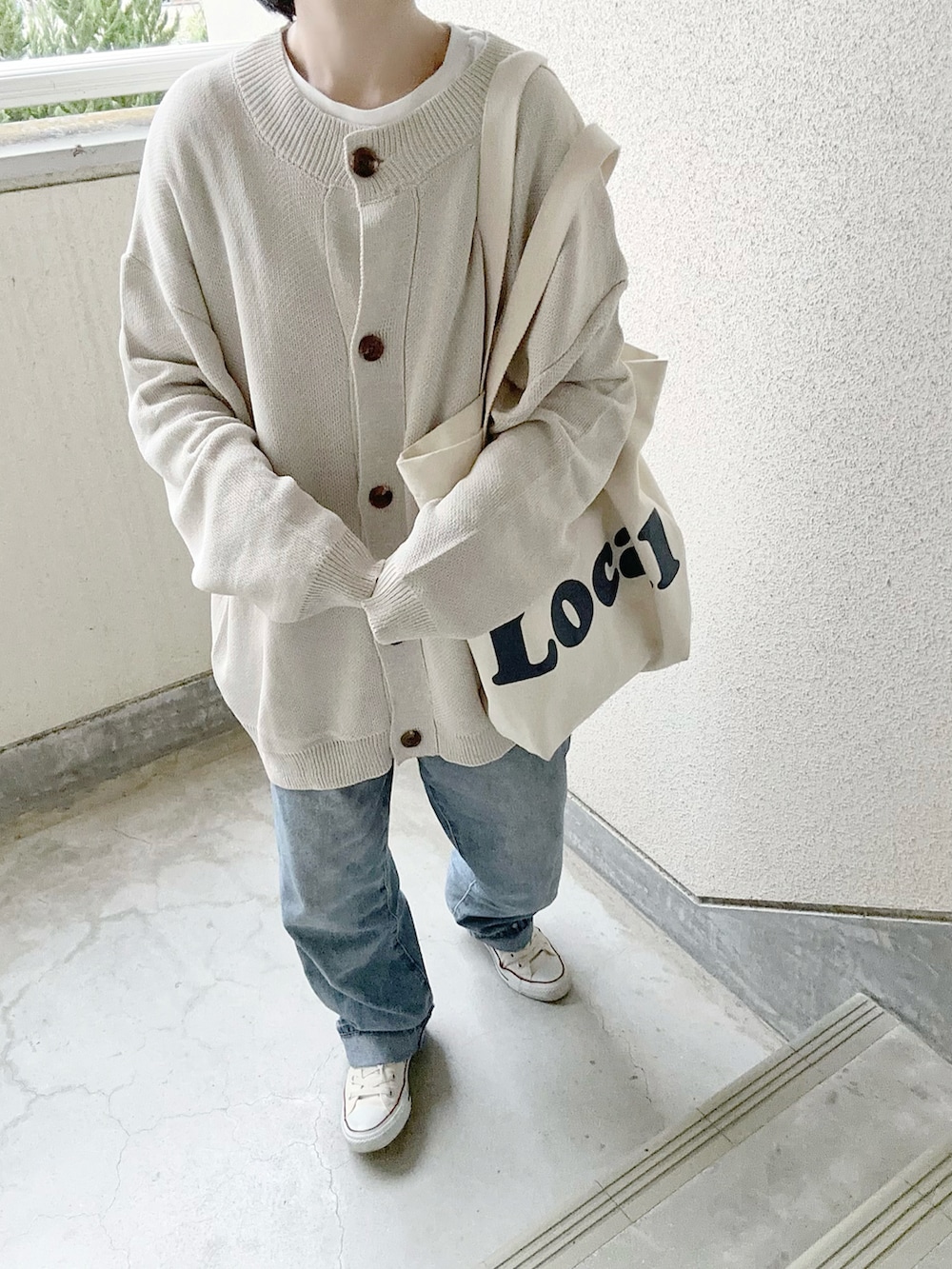 ベージュ系のカーディガン/ボレロ、ブルー系のデニムパンツ、ホワイト系のスニーカーを着用したレディースの冬コーディネートの2枚目の写真