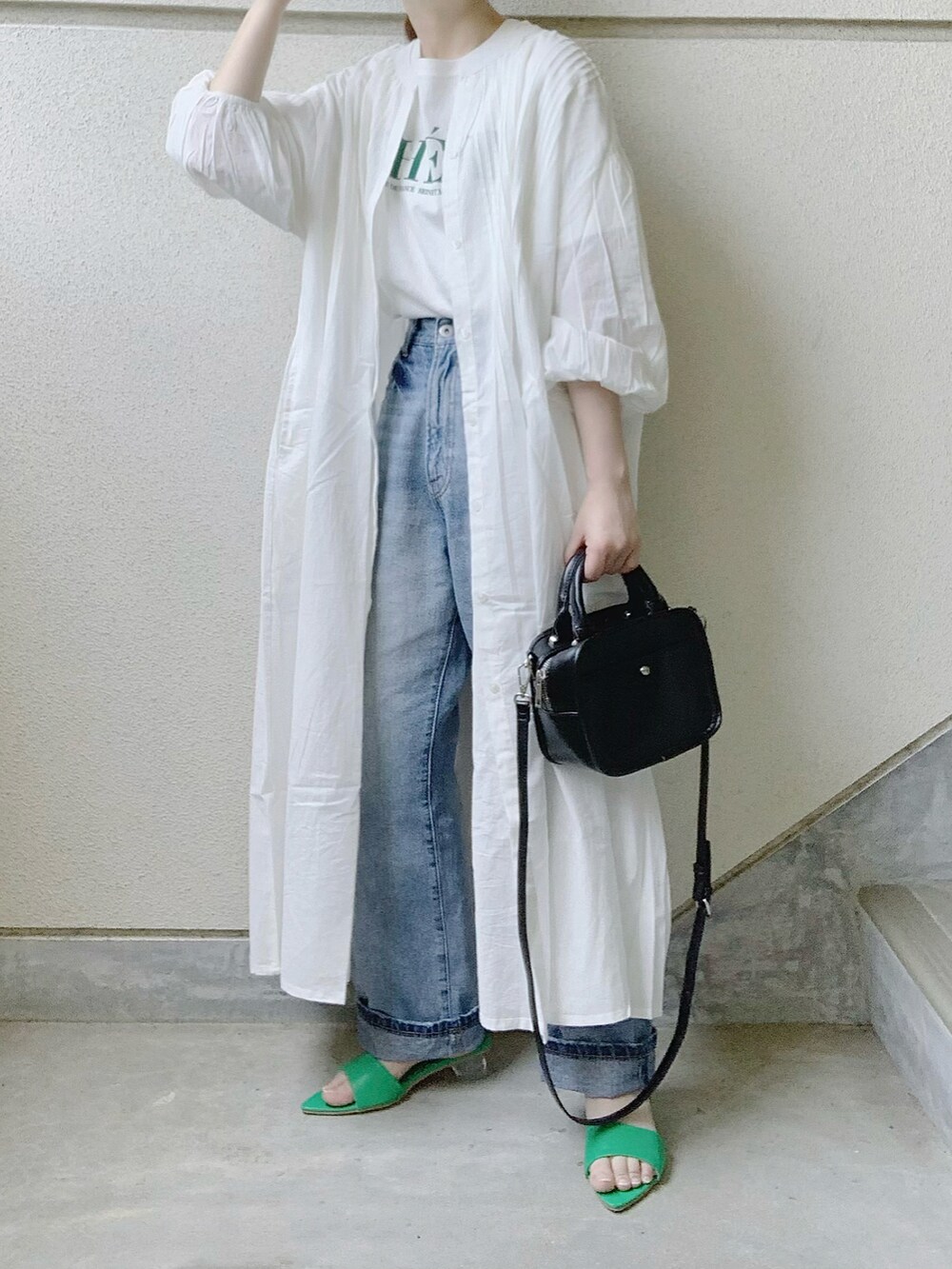 ホワイト系のシャツワンピース、ホワイト系のTシャツ/カットソー、ブルー系のデニムパンツを着用したレディースの夏コーディネートの2枚目の写真