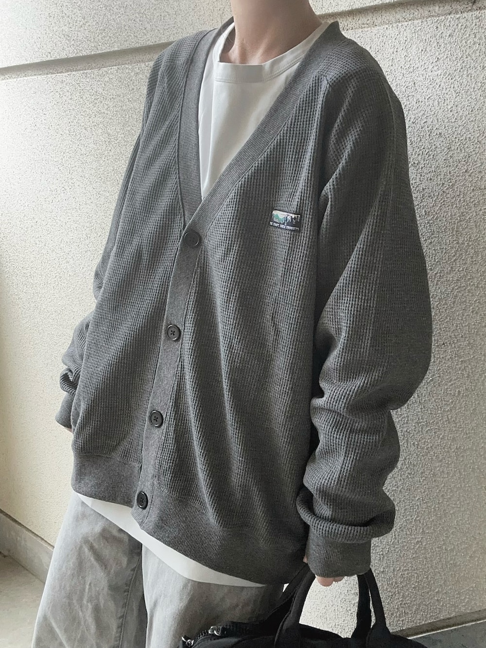 グレー系のカーディガン/ボレロ、ブラック系のショルダーバッグを着用したレディースの冬コーディネートの2枚目の写真