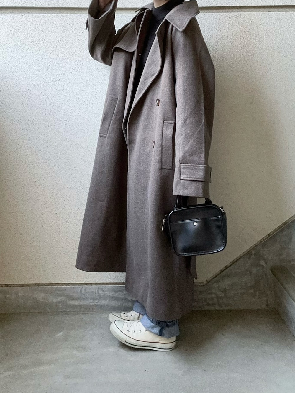 ブラウン系のチェスターコート、ブルー系のデニムパンツを着用したレディースの秋コーディネートの2枚目の写真