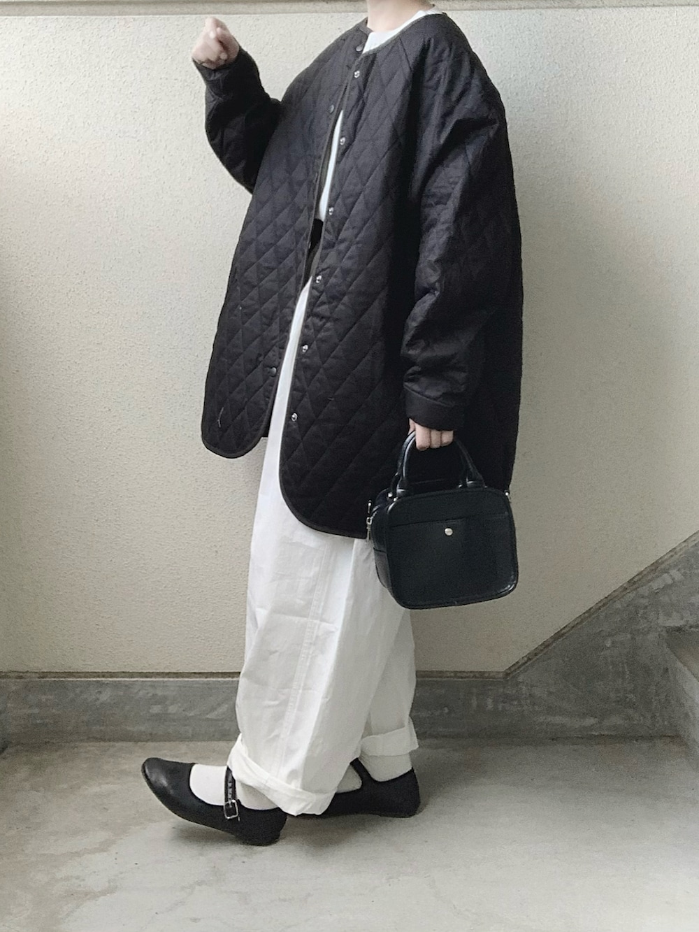 ブラック系のノーカラーコート、ホワイト系のシャツ/ブラウス、ホワイト系のデニムパンツを着用したレディースの秋コーディネートの3枚目の写真