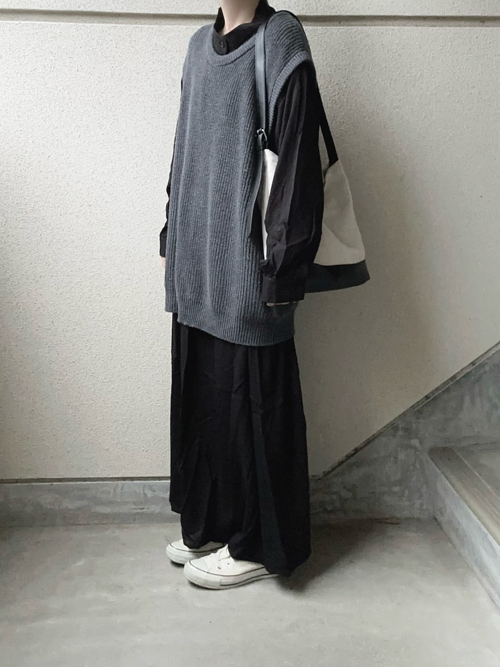 ブラック系のワンピース、グレー系のニット/セーター、ブラック系のトートバッグを着用したレディースの冬コーディネートの2枚目の写真