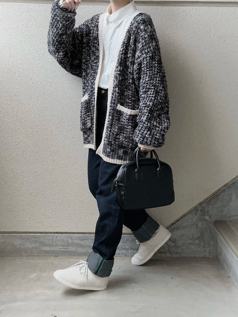 ブラック系のカーディガン/ボレロ、ホワイト系のシャツ/ブラウス、ブルー系のデニムパンツを着用したレディースの冬コーディネートの2枚目の写真