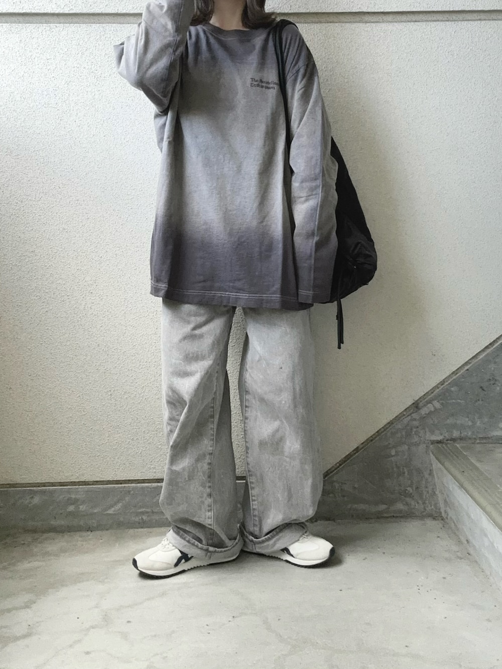 グレー系のTシャツ/カットソー、ブラック系のバックパック/リュック、グレー系のデニムパンツを着用したレディースの冬コーディネートの3枚目の写真