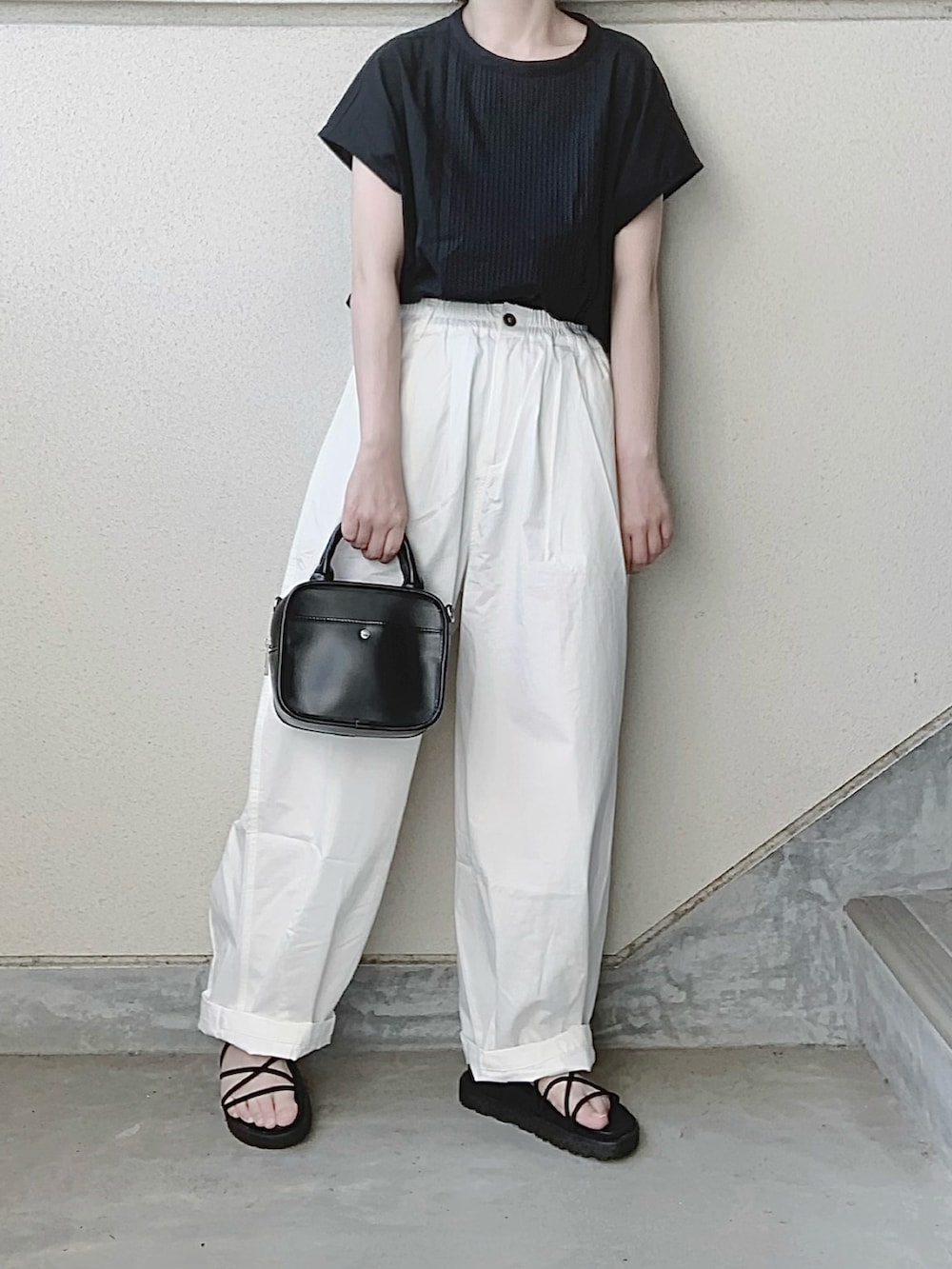 ブラック系のシャツ/ブラウス、ホワイト系のチノパンツ、ブラック系のサンダルを着用したレディースの夏コーディネートの2枚目の写真