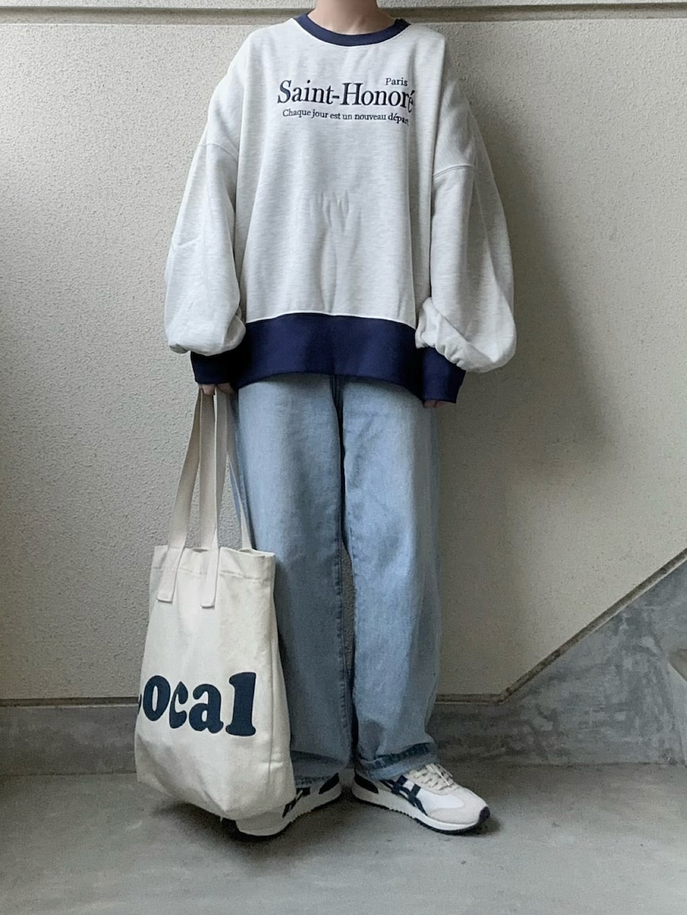 ベージュ系のスウェット、ベージュ系のスニーカー、ブルー系のデニムパンツを着用したレディースの冬コーディネートの2枚目の写真