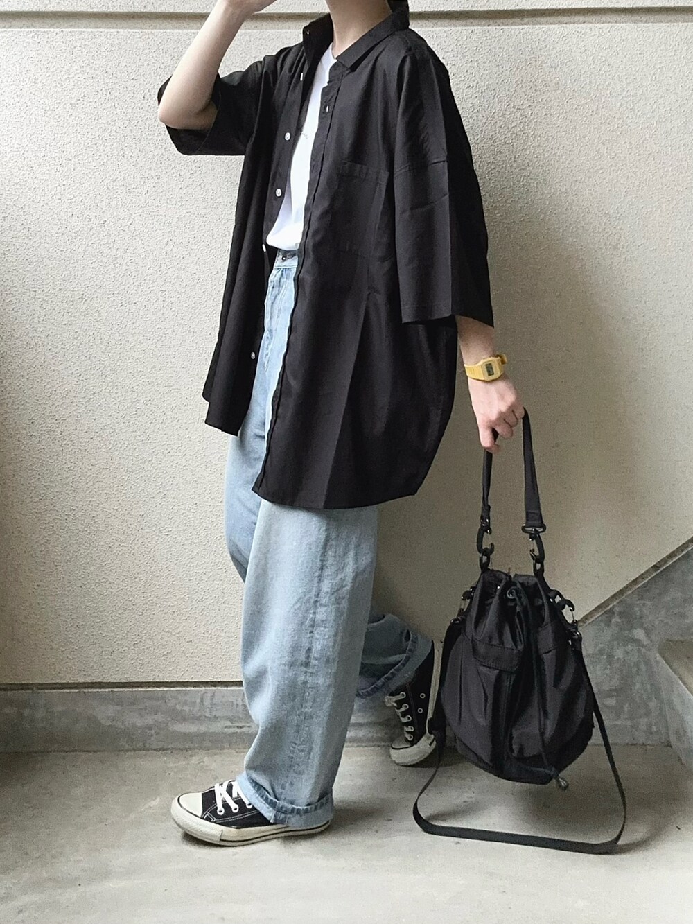 ブラック系のシャツ/ブラウス、ブラック系のショルダーバッグ、ブルー系のデニムパンツを着用したレディースの春コーディネートの3枚目の写真