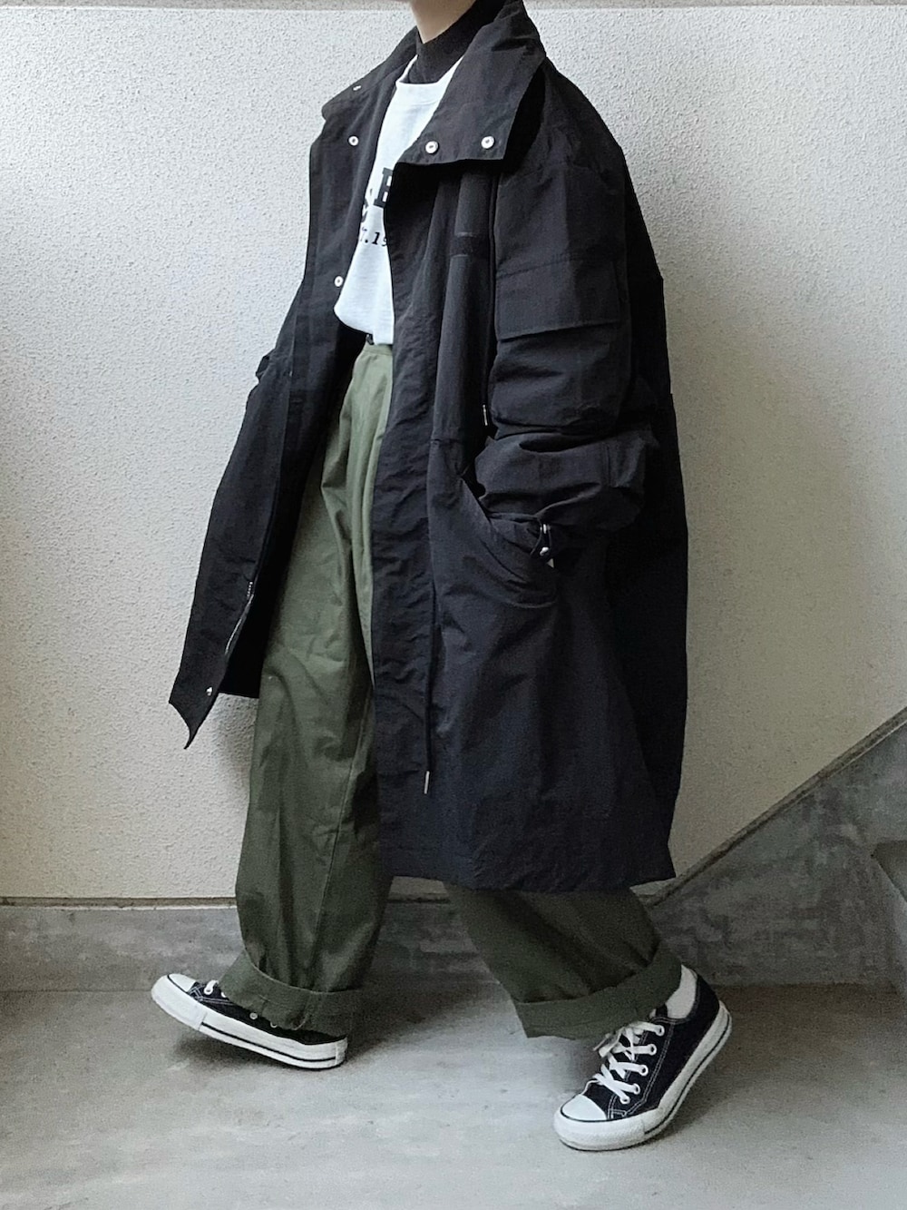 ブラック系のモッズコート、グリーン系のカーゴパンツ、ブラック系のニット/セーターを着用したレディースの秋コーディネートの3枚目の写真