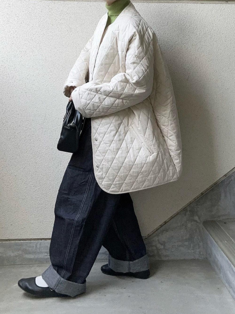 ホワイト系のノーカラージャケット、ブルー系のデニムパンツ、グリーン系のニット/セーターを着用したレディースの秋コーディネートの2枚目の写真