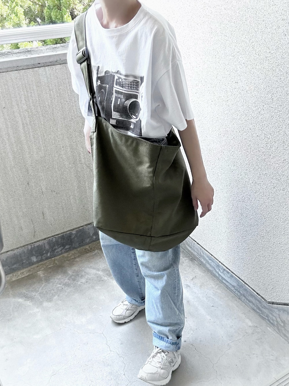 ブラック系のTシャツ/カットソー、グリーン系のショルダーバッグを着用したレディースの夏コーディネートの5枚目の写真