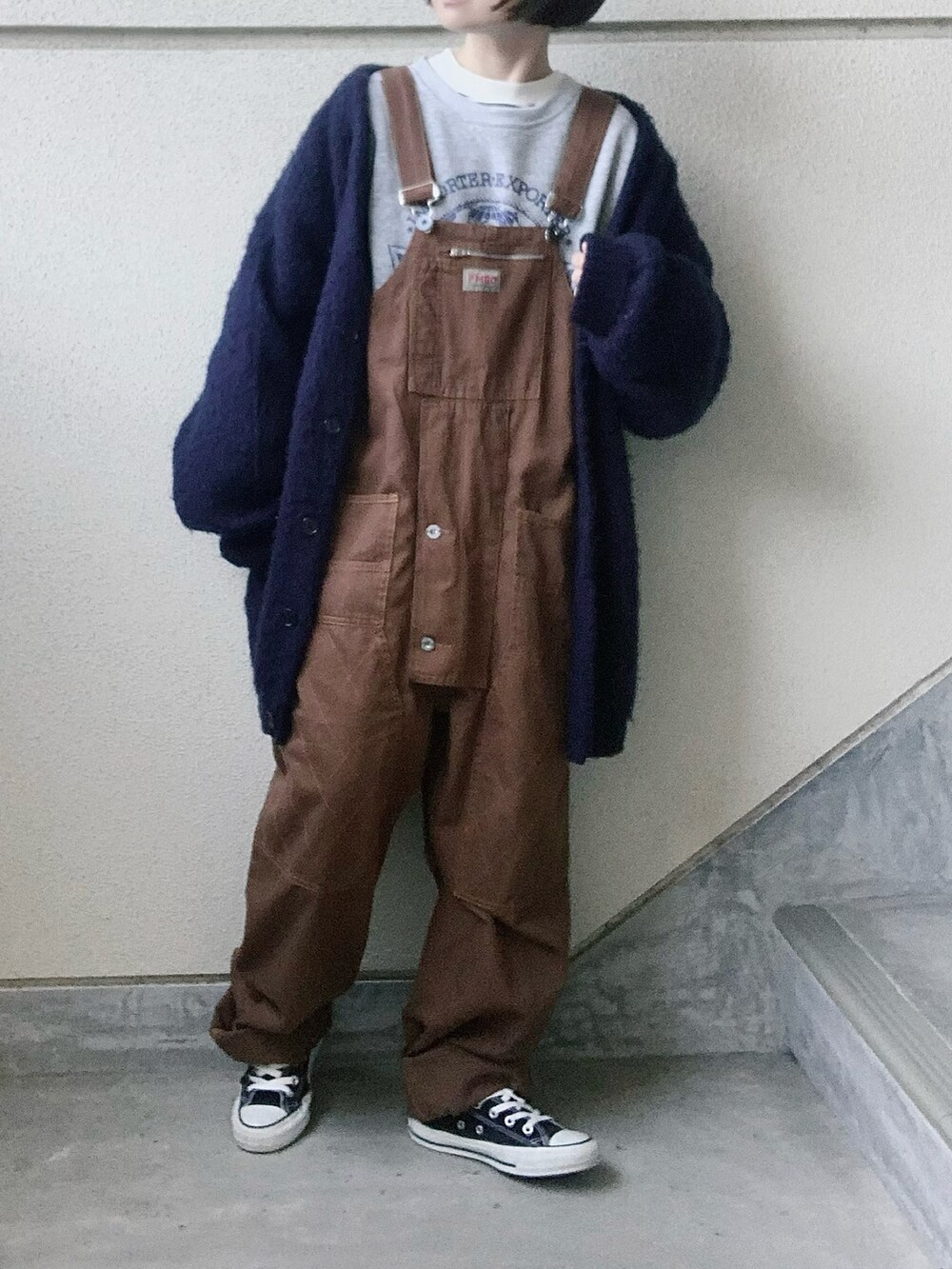 ブラウン系のサロペット/オーバーオール、グレー系のスウェット、ブラック系のスニーカーを着用したレディースの冬コーディネートの4枚目の写真