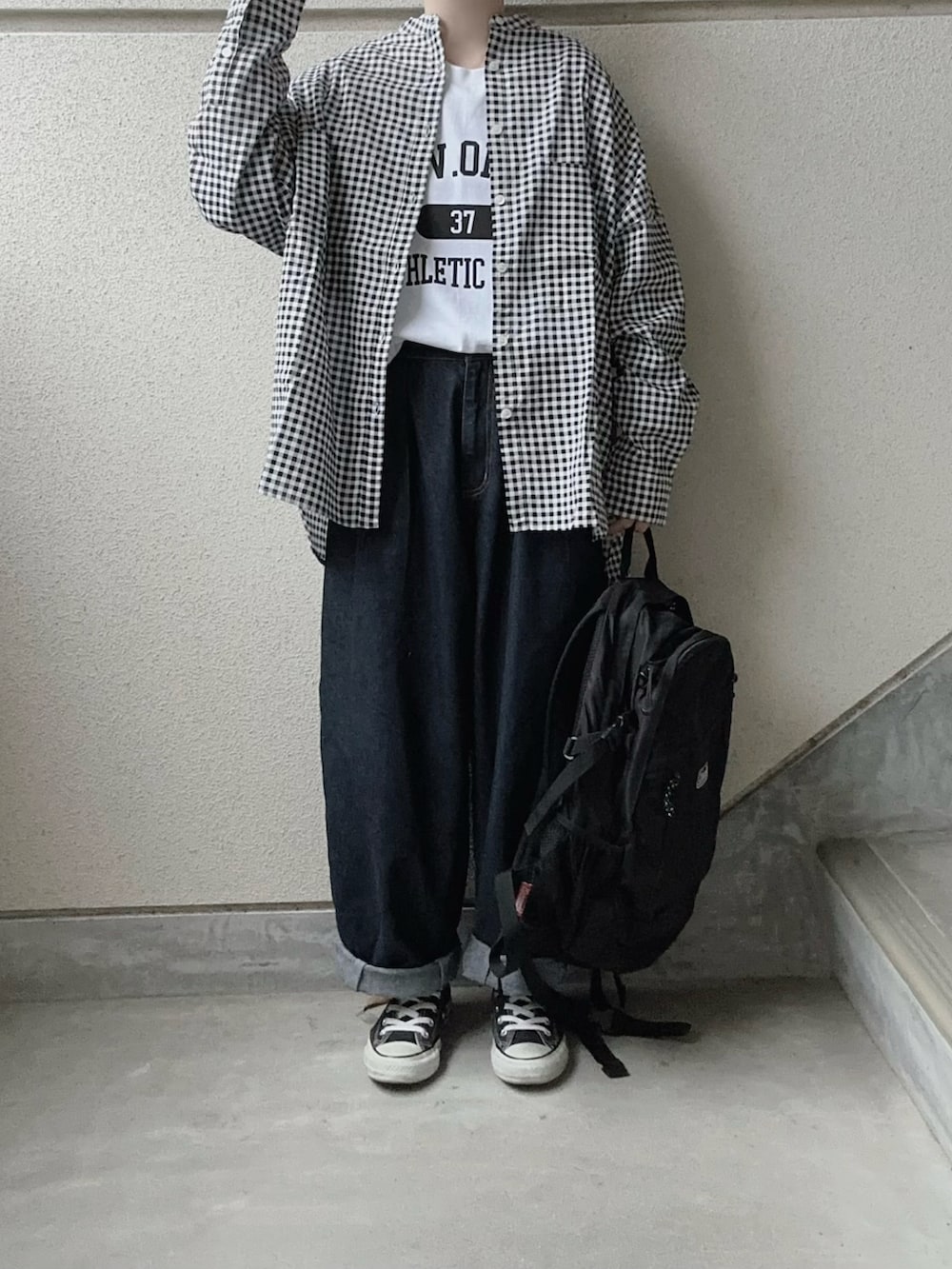 ブラック系のシャツ/ブラウス、ホワイト系のTシャツ/カットソー、ブルー系のデニムパンツを着用したレディースの冬コーディネートの2枚目の写真