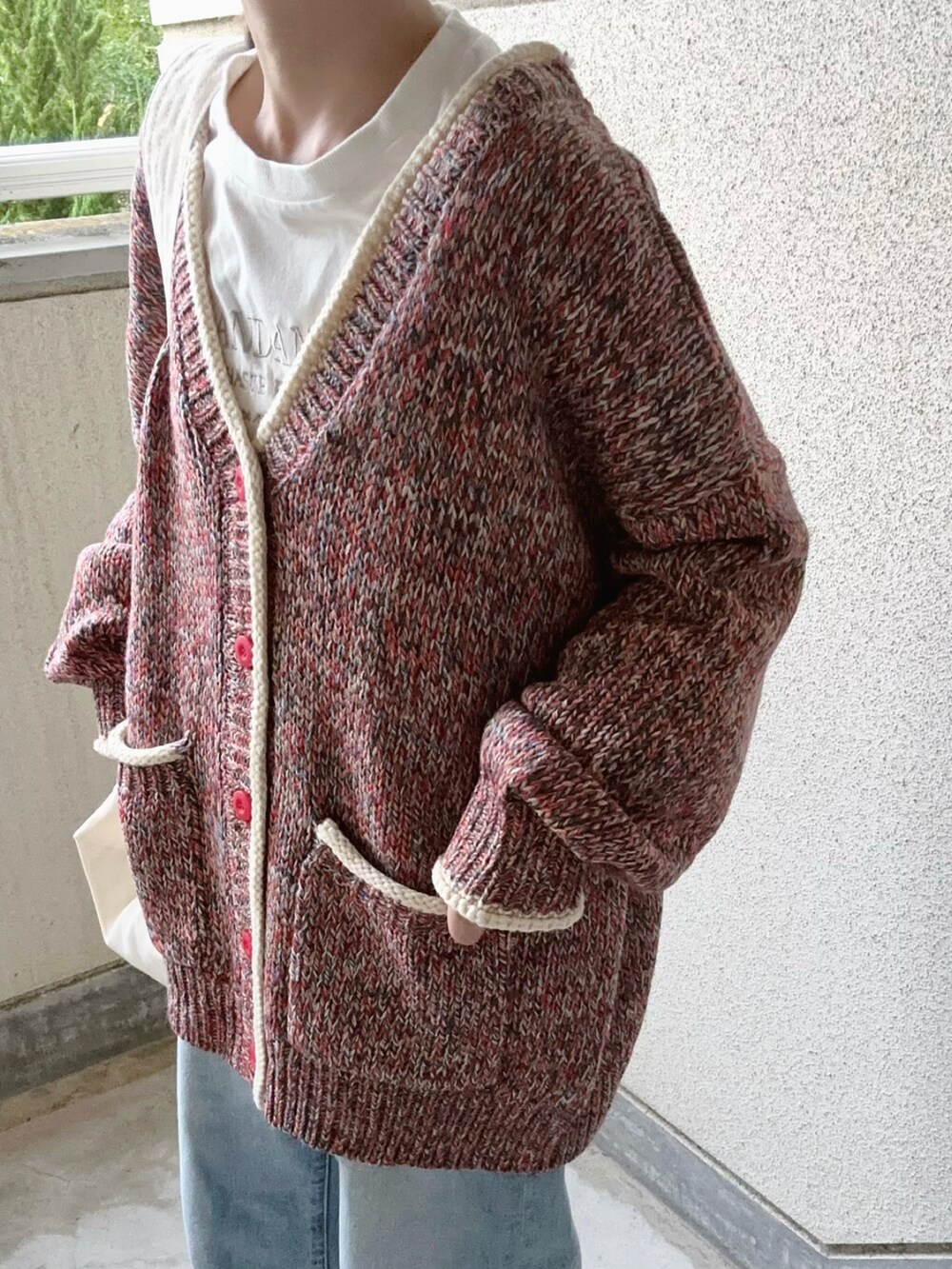 レッド系のカーディガン/ボレロ、ベージュ系のショルダーバッグを着用したレディースの秋コーディネートの4枚目の写真