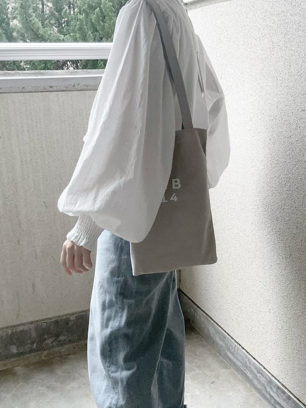 ホワイト系のシャツ/ブラウス、ブルー系のデニムパンツ、グレー系のトートバッグを着用したレディースの春コーディネートの3枚目の写真