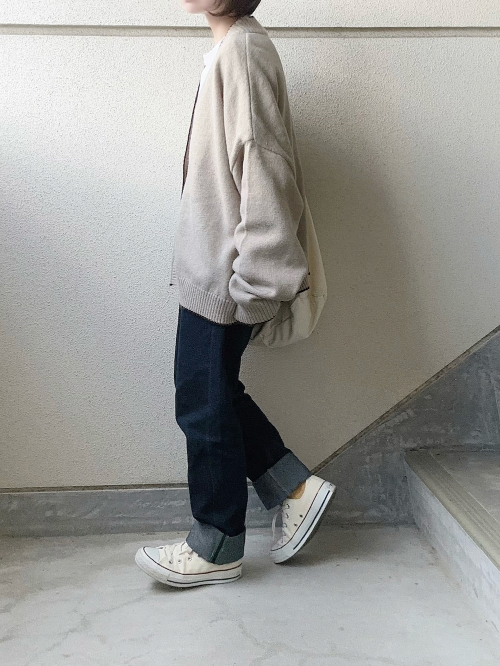 ベージュ系のカーディガン/ボレロ、ホワイト系のTシャツ/カットソー、ホワイト系のショルダーバッグを着用したレディースの冬コーディネートの3枚目の写真