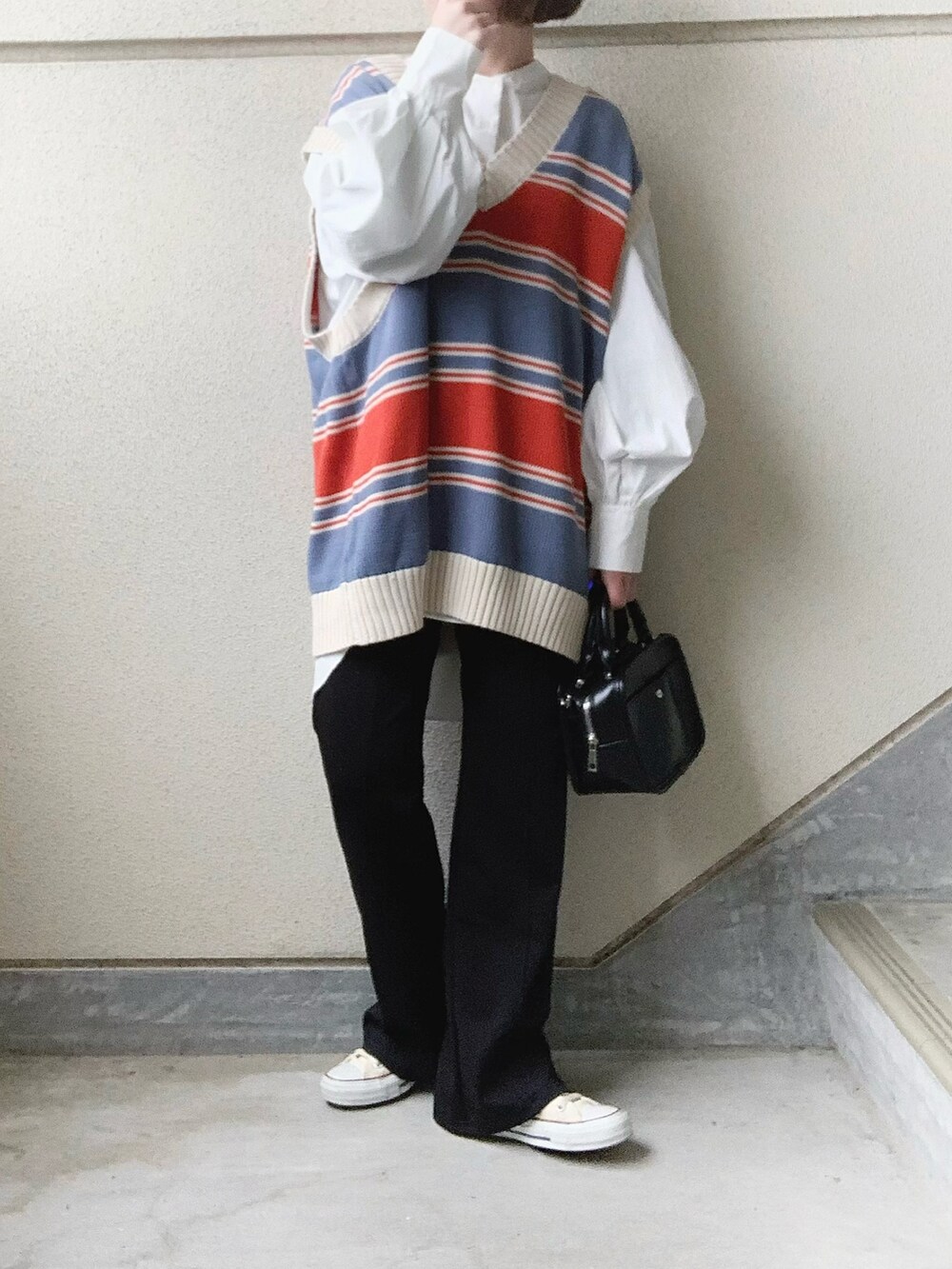 ブルー系のベスト、ブラック系のその他パンツ、ホワイト系のシャツ/ブラウスを着用したレディースの春コーディネートの3枚目の写真