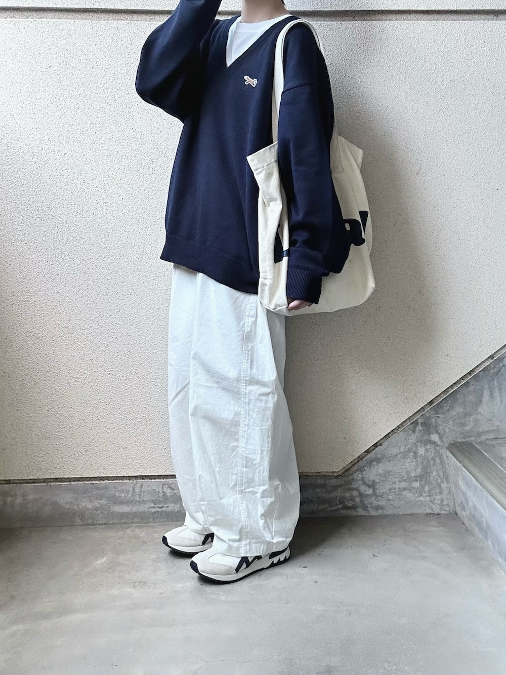 ブルー系のニット/セーター、ホワイト系のチノパンツ、ベージュ系のスニーカーを着用したレディースの秋コーディネートの2枚目の写真