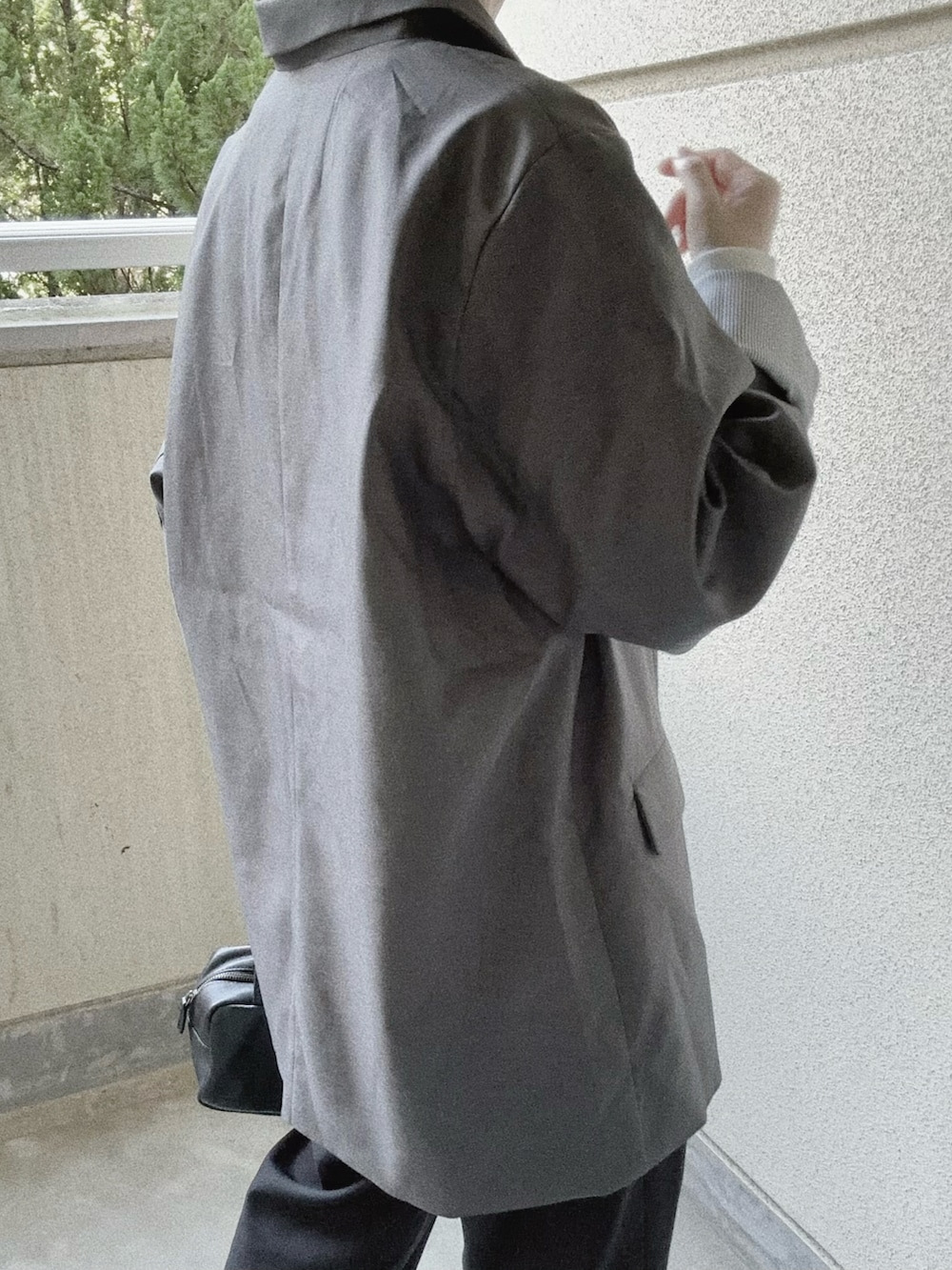 グレー系のテーラードジャケット、ブラック系のボストンバッグを着用したレディースの秋コーディネートの5枚目の写真