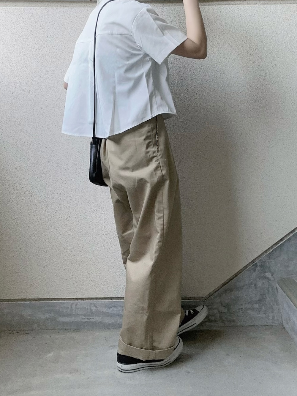 ホワイト系のシャツ/ブラウス、ベージュ系のチノパンツ、ブラック系のショルダーバッグを着用したレディースの春コーディネートの4枚目の写真