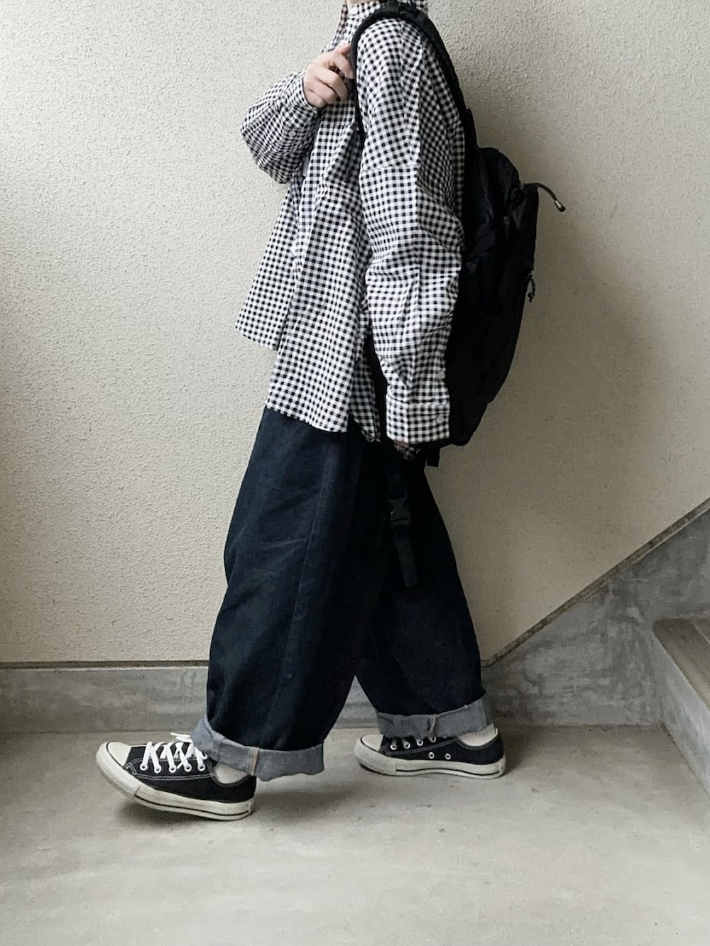 ブラック系のシャツ/ブラウス、ホワイト系のTシャツ/カットソー、ブルー系のデニムパンツを着用したレディースの冬コーディネートの3枚目の写真