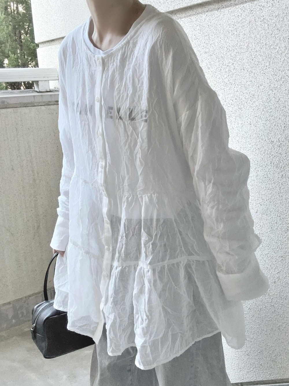 ホワイト系のシャツ/ブラウス、グレー系のデニムパンツ、ブラック系のボストンバッグを着用したレディースの春コーディネートの5枚目の写真