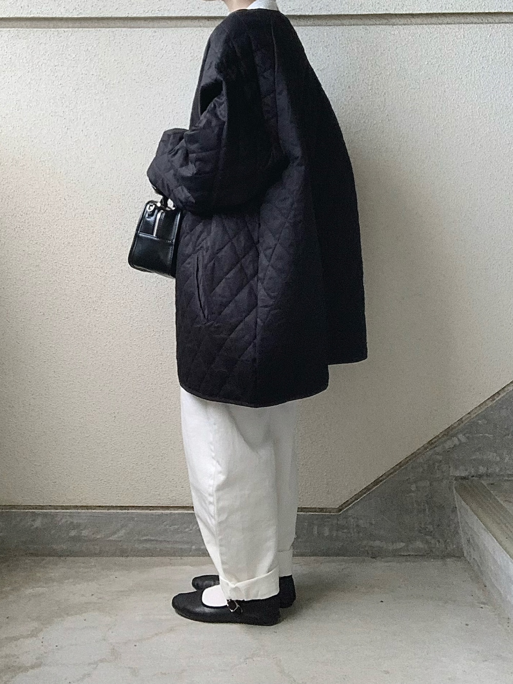 ブラック系のノーカラーコート、ホワイト系のシャツ/ブラウス、ホワイト系のデニムパンツを着用したレディースの秋コーディネートの4枚目の写真