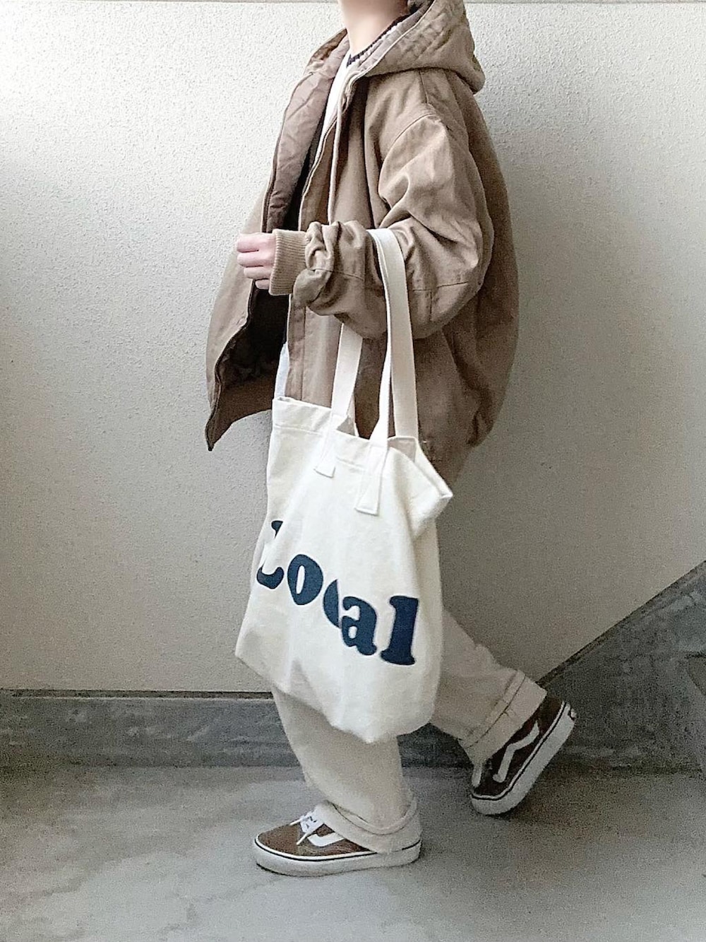 ホワイト系のニット/セーター、ホワイト系のデニムパンツを着用したレディースの冬コーディネートの2枚目の写真