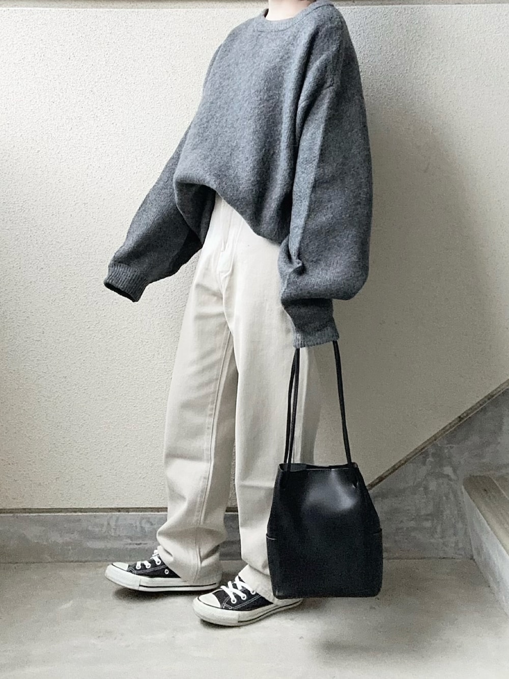 グレー系のニット/セーター、グレー系のデニムパンツを着用したレディースの冬コーディネートの2枚目の写真