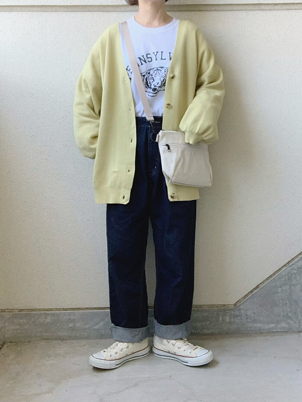 ホワイト系のショルダーバッグ、イエロー系のカーディガン/ボレロ、ホワイト系のTシャツ/カットソーを着用したレディースの春コーディネートの2枚目の写真