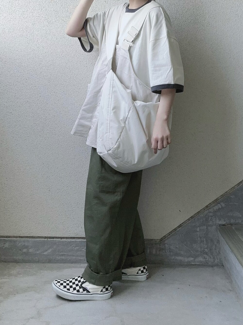 ホワイト系のベスト、グレー系のTシャツ/カットソー、グリーン系のカーゴパンツを着用したレディースの春コーディネートの2枚目の写真