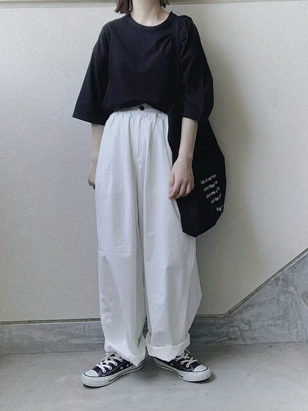 ブラック系のTシャツ/カットソー、ホワイト系のチノパンツ、ブラック系のトートバッグを着用したレディースの夏コーディネートの4枚目の写真