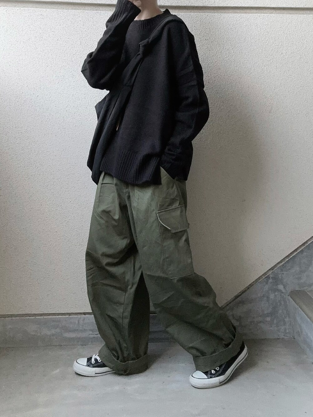 ブラック系のニット/セーター、グリーン系のカーゴパンツを着用したレディースの冬コーディネートの3枚目の写真