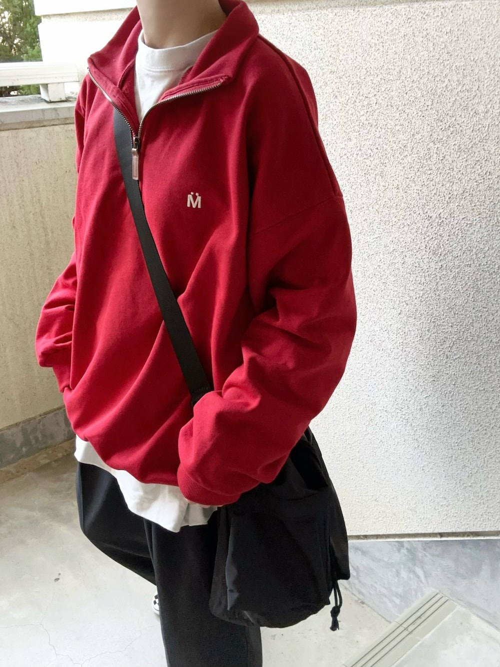 ブラック系のショルダーバッグ、レッド系のスウェットを着用したレディースの冬コーディネートの4枚目の写真