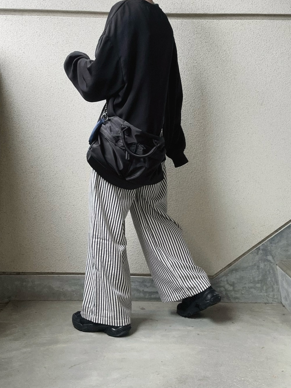 ブラック系のその他パンツ、ブラック系のTシャツ/カットソー、ブラック系のショルダーバッグを着用したレディースの春コーディネートの3枚目の写真
