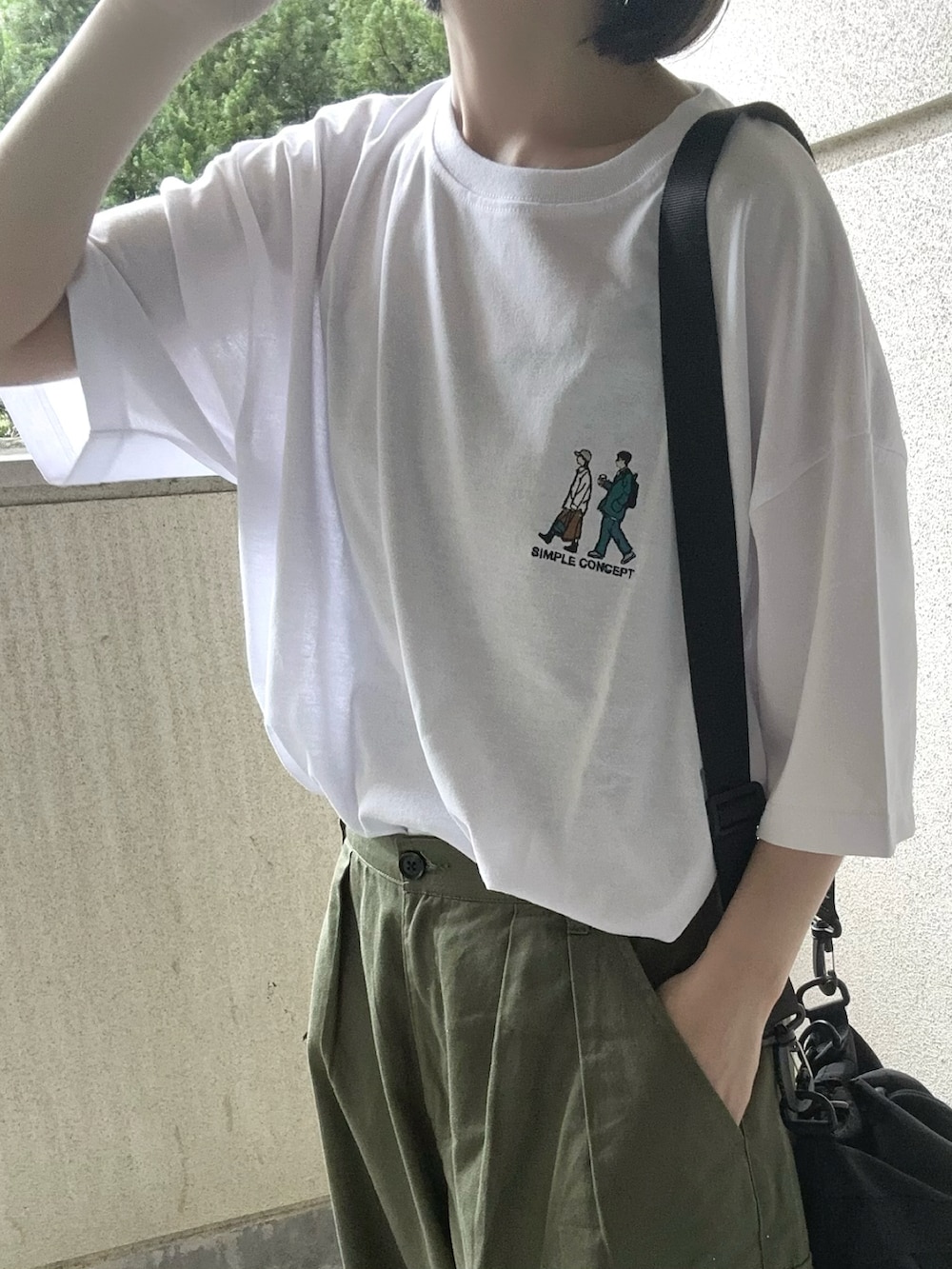 ホワイト系のTシャツ/カットソー、グリーン系のカーゴパンツ、ブラック系のショルダーバッグを着用したレディースの春コーディネートの2枚目の写真
