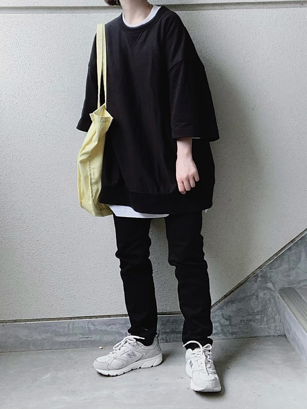 ブラック系のデニムパンツ、ブラック系のTシャツ/カットソー、ホワイト系のTシャツ/カットソーを着用したレディースの春コーディネートの2枚目の写真