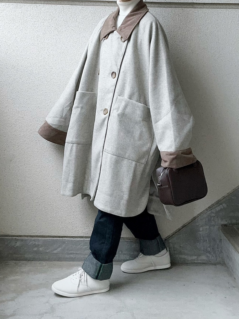 ベージュ系のその他アウター、ホワイト系のニット/セーター、ブラウン系のボストンバッグを着用したレディースの秋コーディネートの2枚目の写真