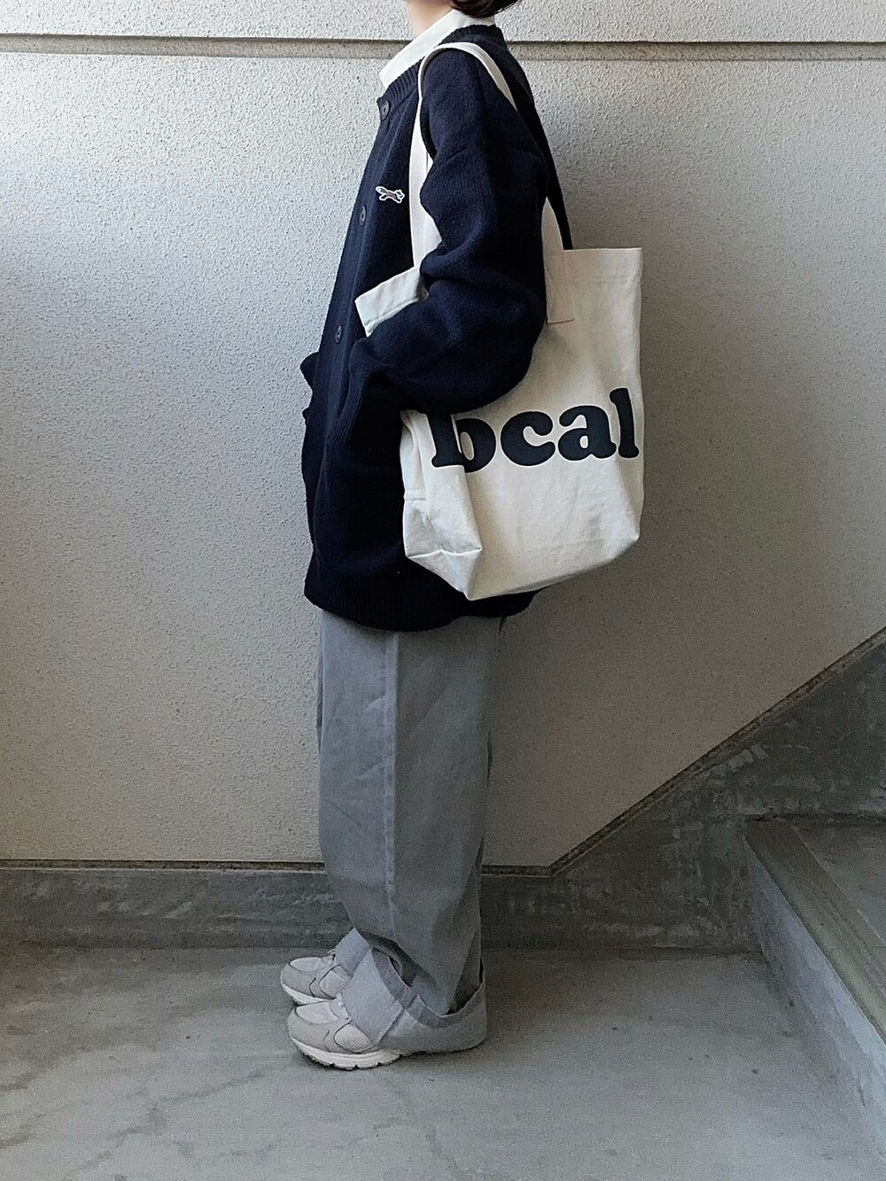 グレー系のデニムパンツ、ブルー系のカーディガン/ボレロ、ホワイト系のシャツ/ブラウスを着用したレディースの冬コーディネートの2枚目の写真