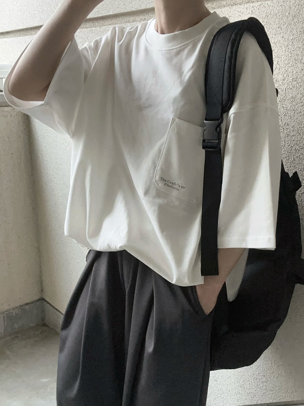 ホワイト系のTシャツ/カットソー、グレー系のスラックス、ブラック系のボディバッグ/ウエストポーチを着用したレディースの春コーディネートの5枚目の写真