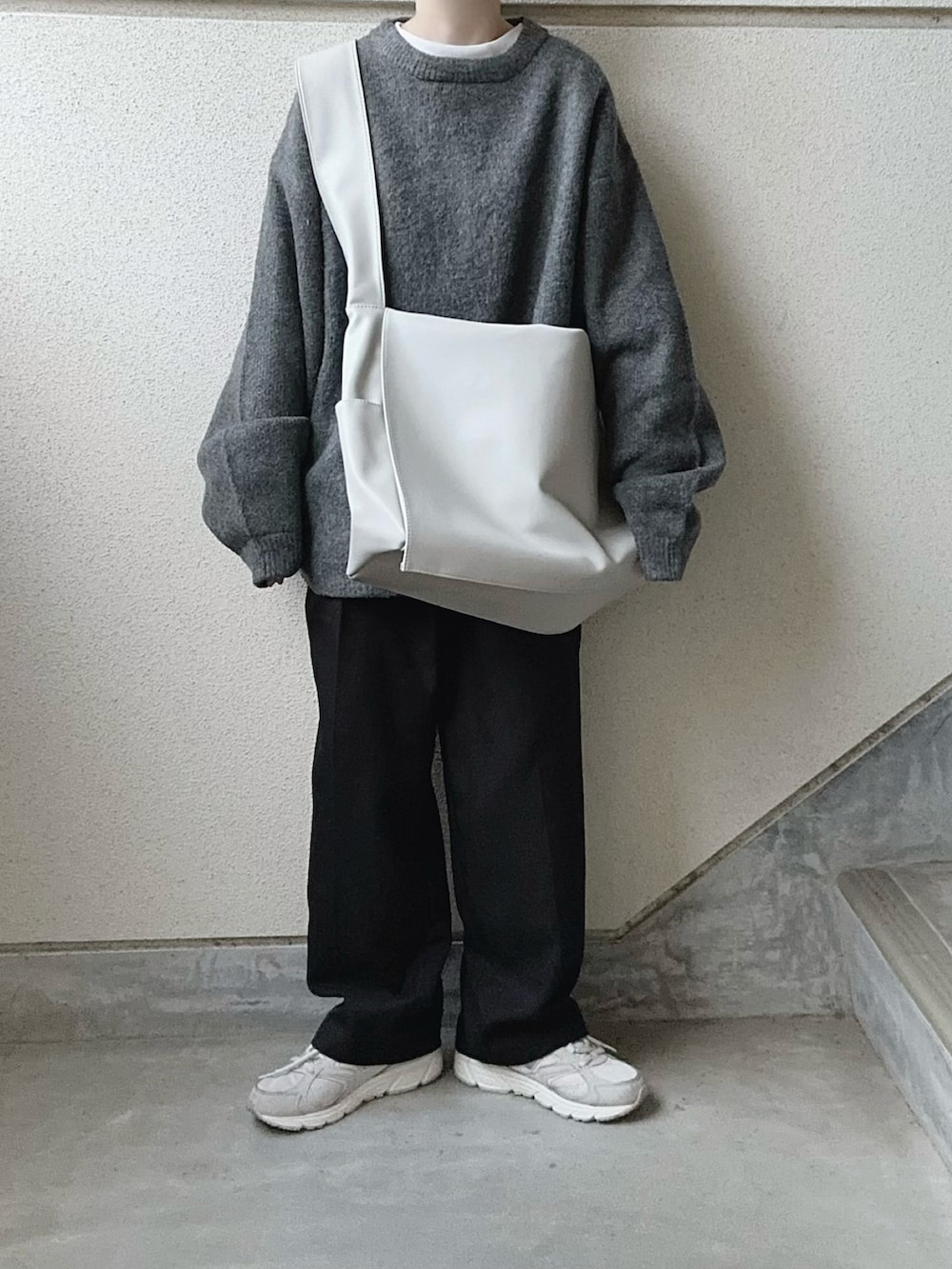 グレー系のニット/セーター、グレー系のショルダーバッグを着用したレディースの冬コーディネートの2枚目の写真