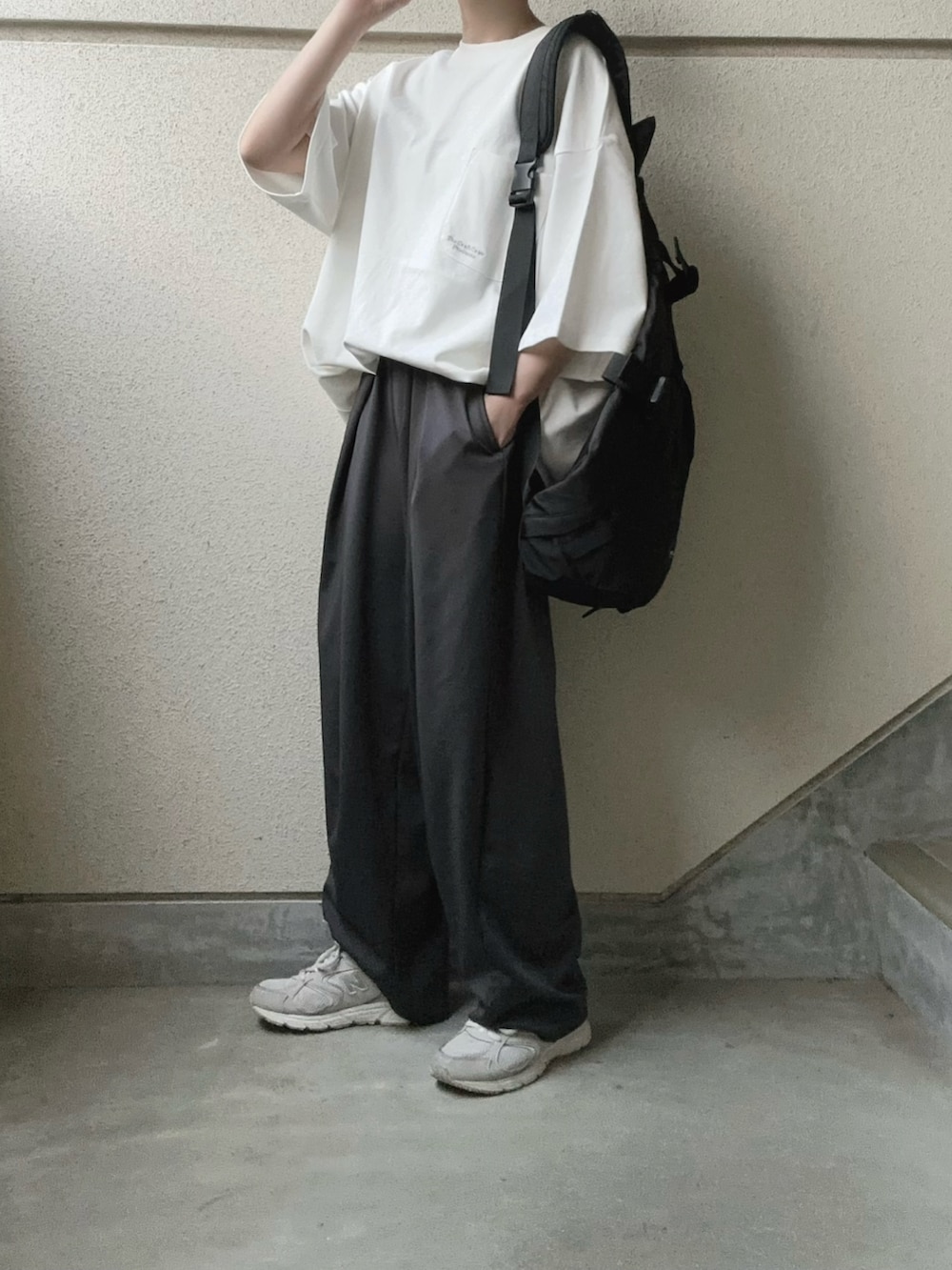 ホワイト系のTシャツ/カットソー、グレー系のスラックス、ブラック系のボディバッグ/ウエストポーチを着用したレディースの春コーディネートの2枚目の写真