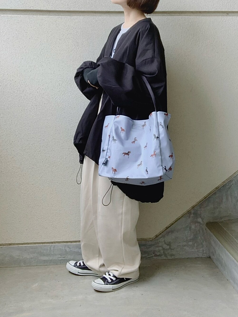 ブルー系のトートバッグ、ホワイト系のTシャツ/カットソー、ブラック系のブルゾンを着用したレディースの春コーディネートの2枚目の写真