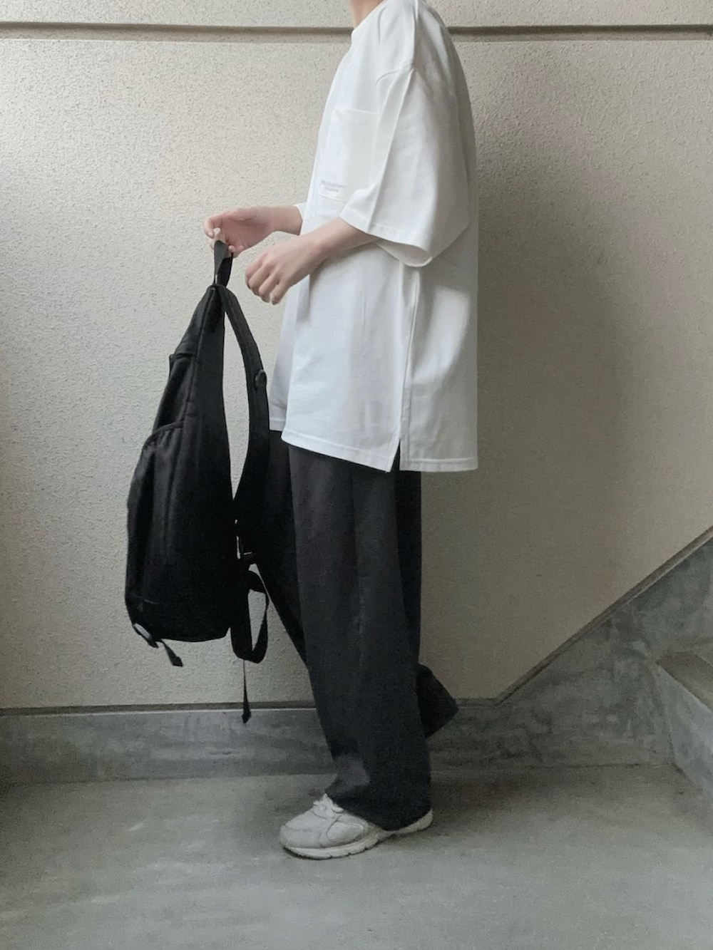 ホワイト系のTシャツ/カットソー、グレー系のスラックス、ブラック系のボディバッグ/ウエストポーチを着用したレディースの春コーディネートの3枚目の写真